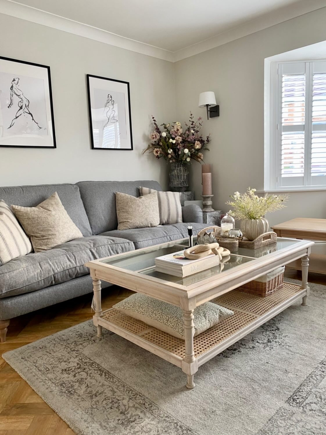Elegant living room decor with an acacia coffee table with rattan and a glass top.