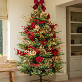 Decorated Christmas tree with red bows and ornaments in a room setting.