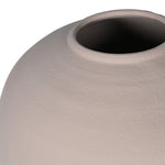 A large round beige vase filled with a narrow opening
