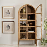 Arched natural elm wood display cabinet with glass doors and five interior shelves, styled with ceramic vases and books in a modern living space