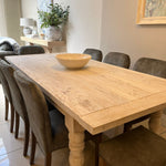 Wooden dining table with chairs in a room with decor elements.