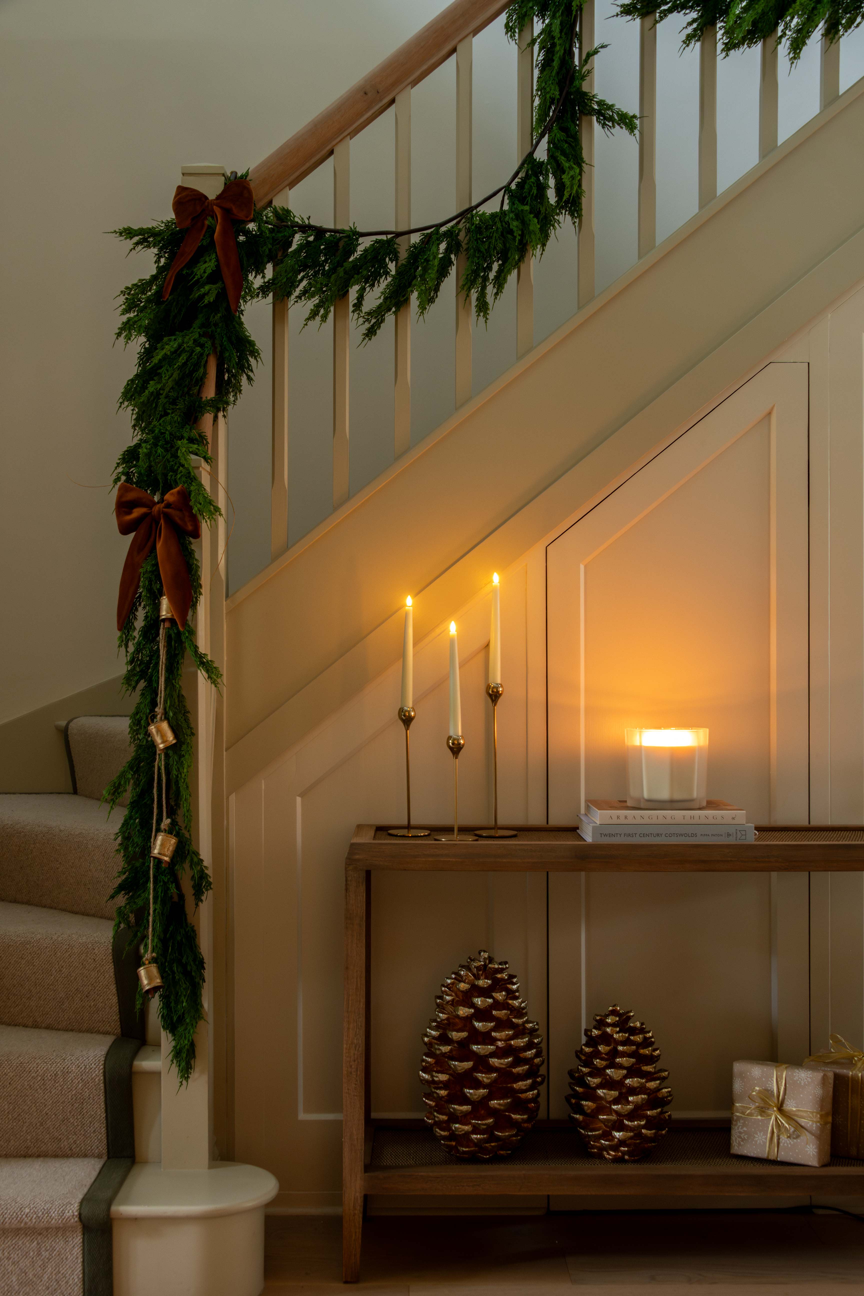 Decorative staircase with greenery, candles, and decorative items in a warm indoor setting.