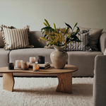 Living room with a beige sofa, wooden coffee table, and decorative items.