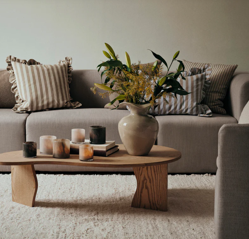 Living room with a beige sofa, wooden coffee table, and decorative items.