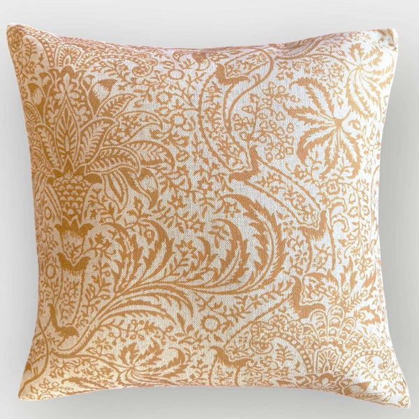 A square-shaped cushion with a floral pattern in an ocre color on a linen base.