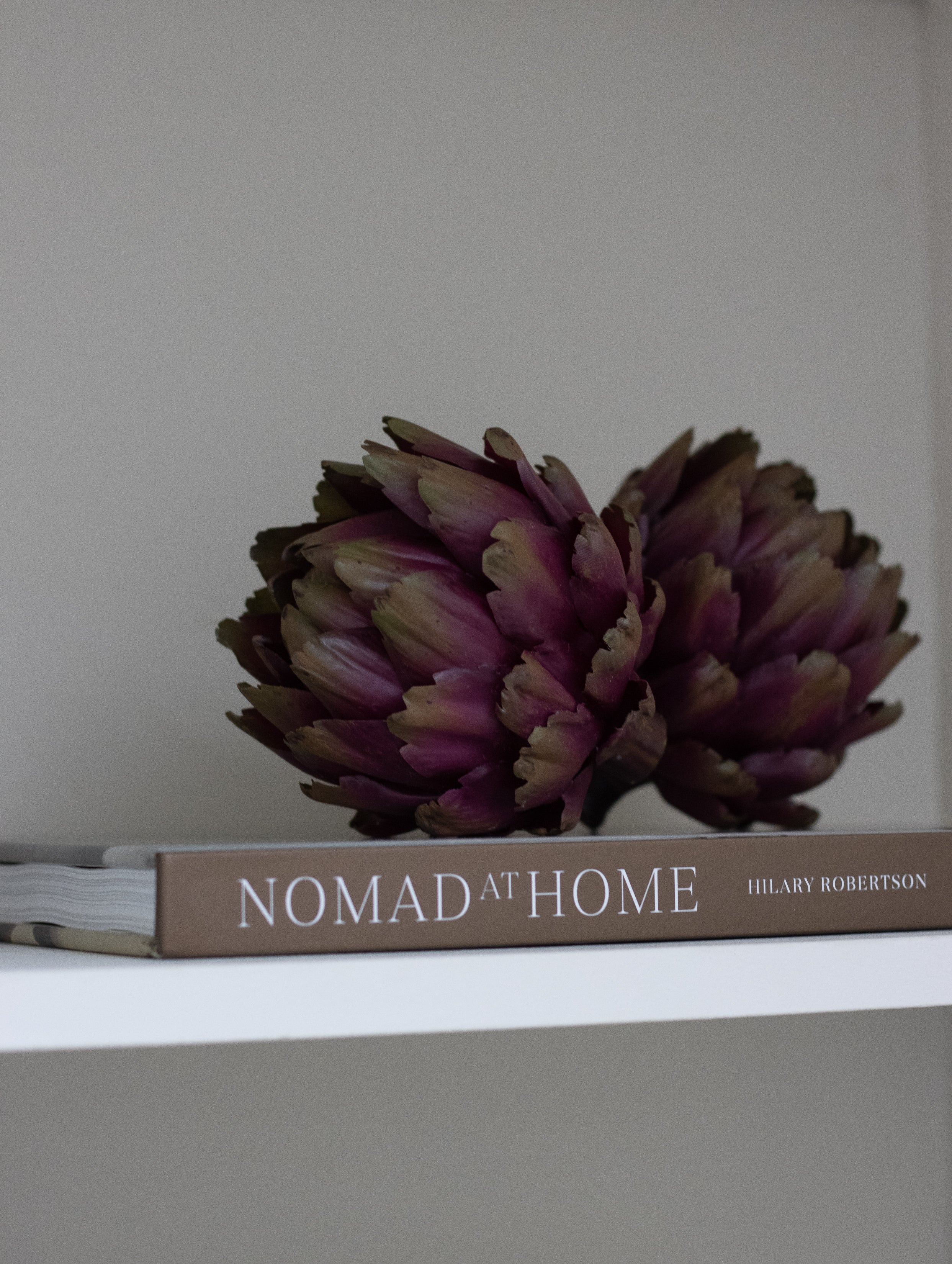 A set of three decorative faux green and purple artichokes.