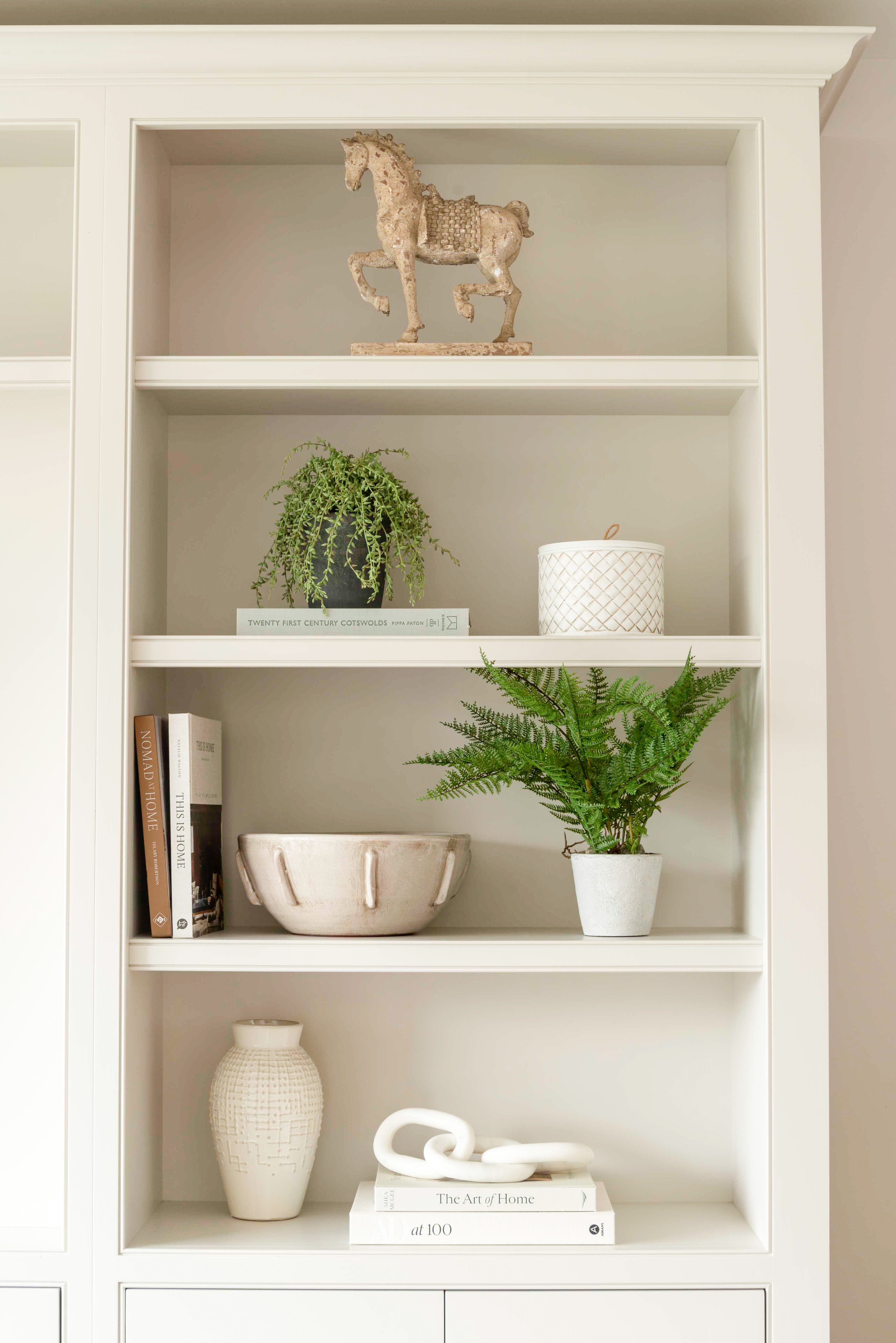 A decorative faux green fern planted in a stone pot.