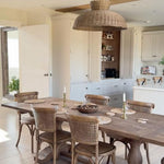 Caledonia rattan ceiling light styled above rustic dining table in neutral-toned kitchen