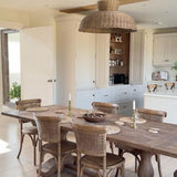 Caledonia rattan ceiling light styled above rustic dining table in neutral-toned kitchen