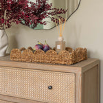 Handwoven seagrass serving tray with scalloped edges and handles