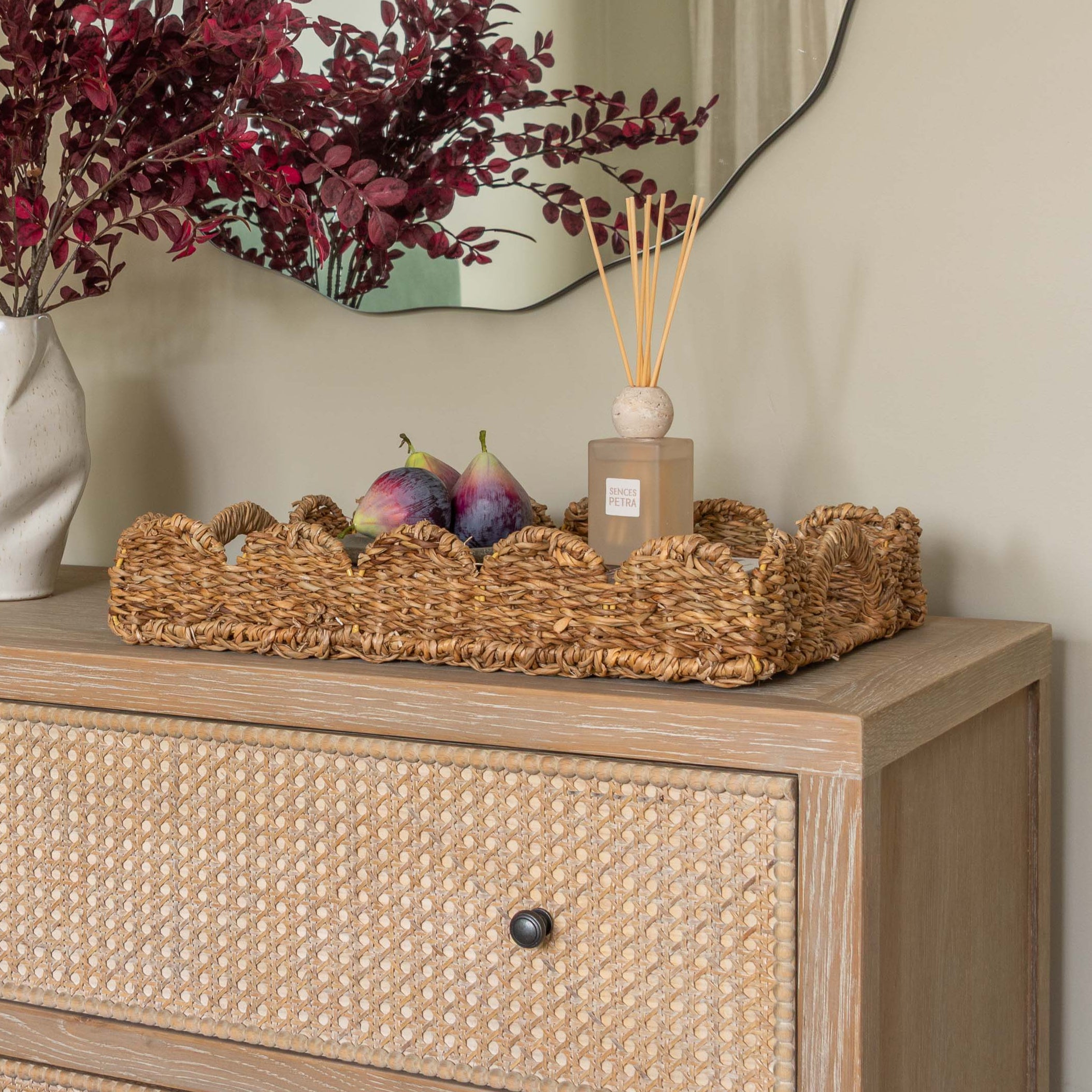 Handwoven seagrass serving tray with scalloped edges and handles