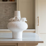 White sculptural porcelain vase with decorative ceramic chain accent around the neck, modern minimalist design