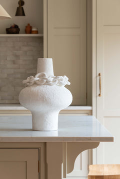 White sculptural porcelain vase with decorative ceramic chain accent around the neck, modern minimalist design