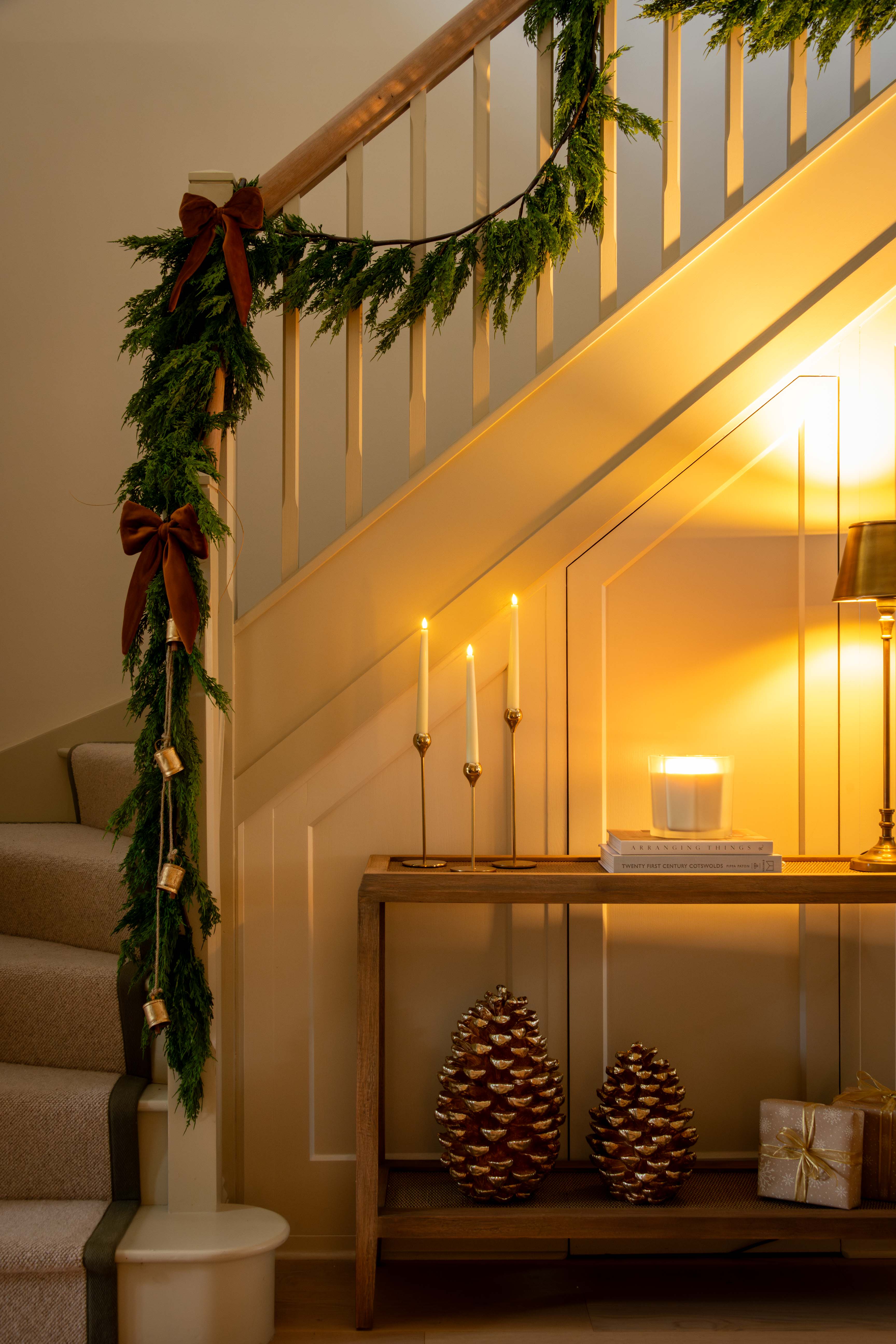 Decorative staircase with Christmas garland, candles, and decorative items.
