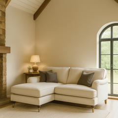 Beige sectional sofa in a living room with a lamp and decorative items.