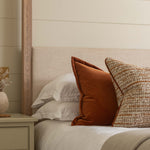 Bedroom with a bed featuring pillows and a wooden headboard against a shiplap wall.