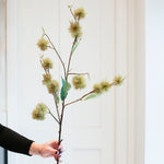 A person holding a artificial chestnut spray decoration.