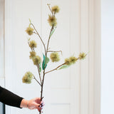 A person holding a artificial chestnut spray decoration.