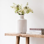 White ceramic vase with a slender bottle-neck design.