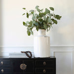 White ceramic vase with a slender bottle-neck design.