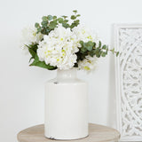 White ceramic vase with a slender bottle-neck design.