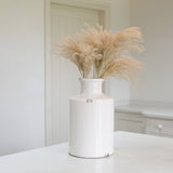 White ceramic vase with a slender bottle-neck design with pampas stems