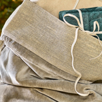 Gift sack made with grey velvet and rustic linen, stuffed with wrapped gifts close up