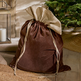 Charles Ted Cotton Velvet Christmas Sack in mocha with linen top and jute tie placed under a Christmas tree by a fireplace