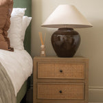 Charles Ted Evelyn Rustic Grey Oak Bedside Table with 2 Rattan Latticed Drawers beside bed with lamp