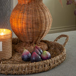 Realistic faux figs displayed with wicker vase and candle