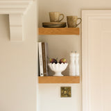 A set of 3 faux figs placed in a bowl on a shelf