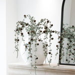 Charles Ted Faux Green Draping Larix Spray with realistic greenery and pine cones displayed in a white vase on a mantel