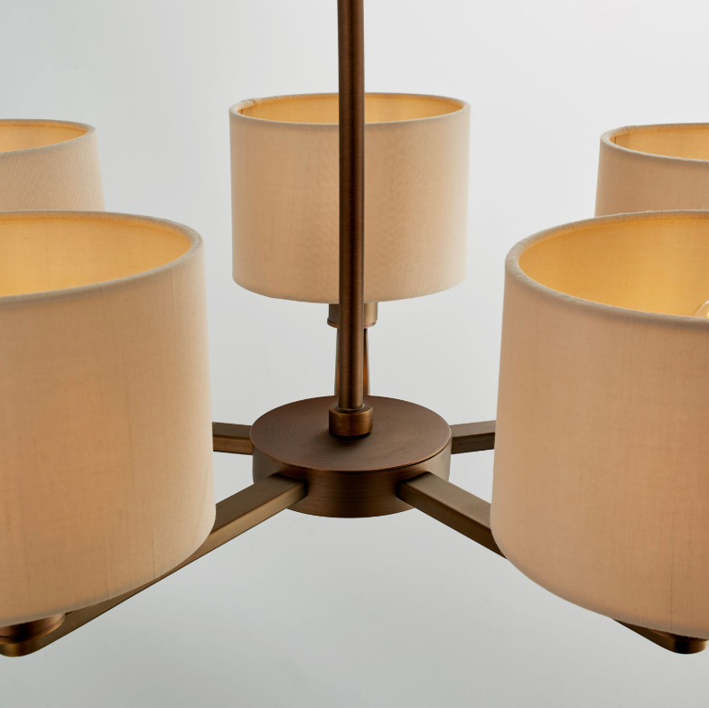 Chandelier with four beige lampshades on a light gray background