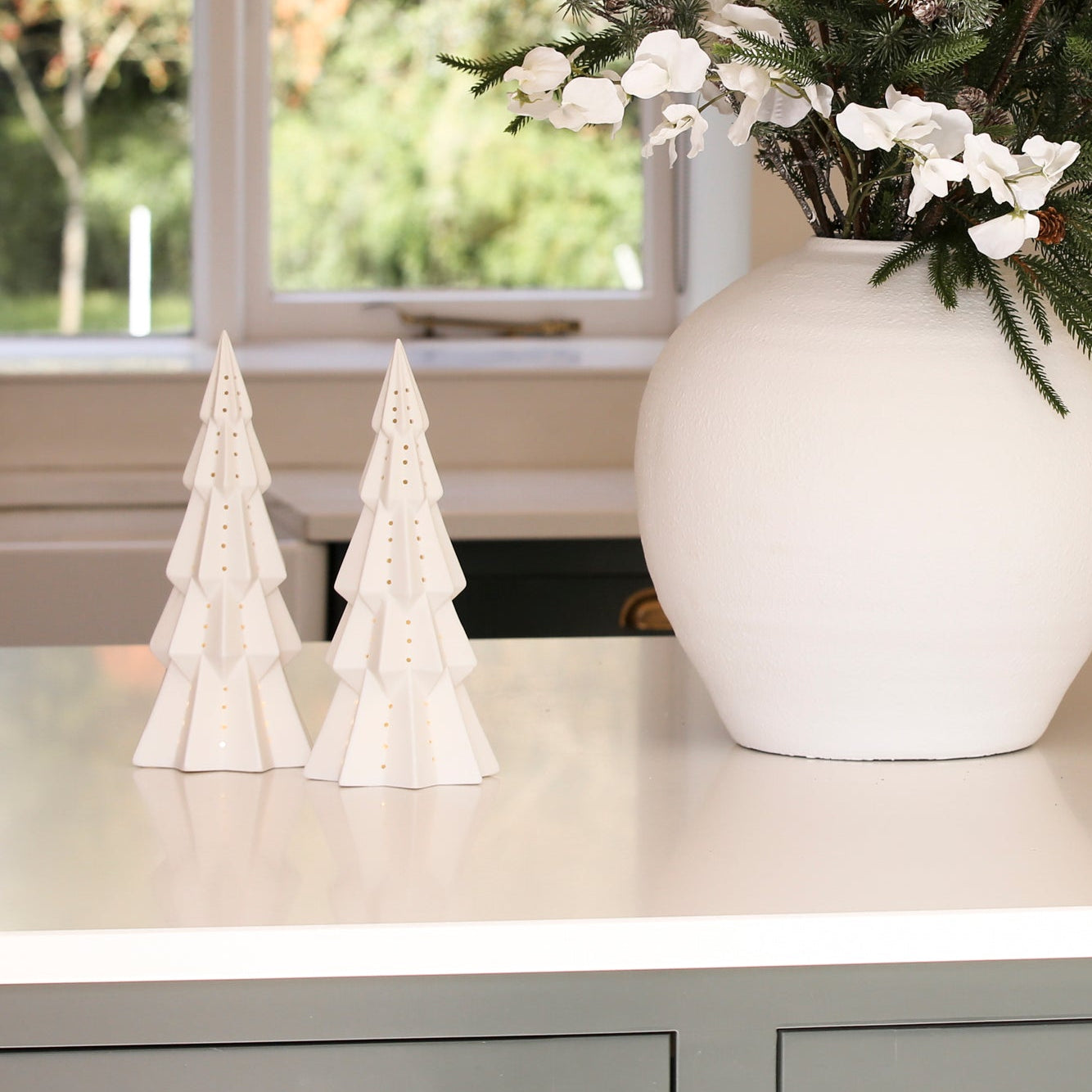 Charles Ted Lit Decorative Christmas Tree styled on a counter next to a festive floral arrangement
