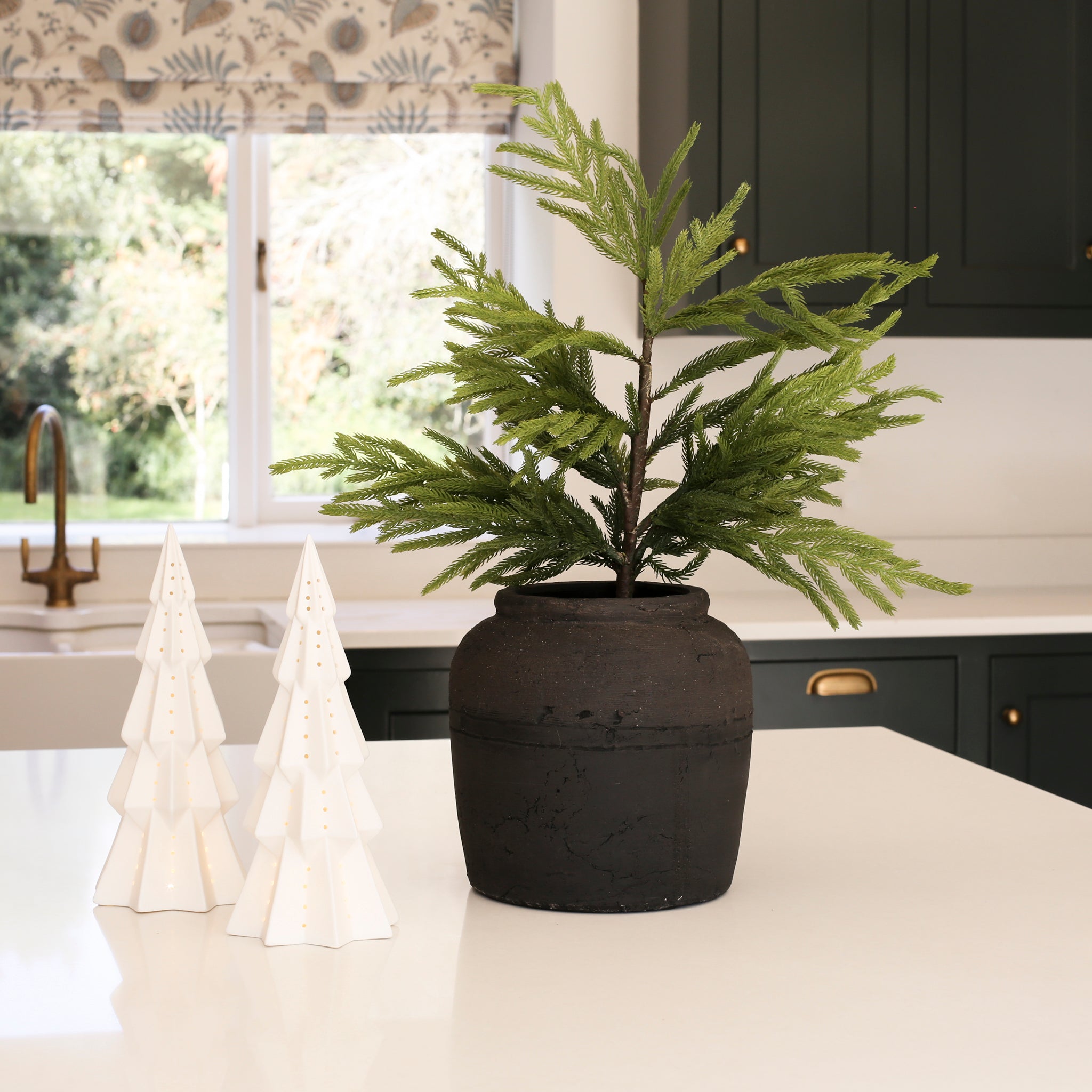 White lit decorative Christmas tree ornament by Charles Ted on a kitchen counter