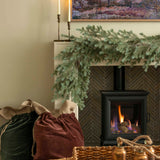 Charles Ted Noble Pine Garland with realistic pine branches and cones styled across a fireplace mantel