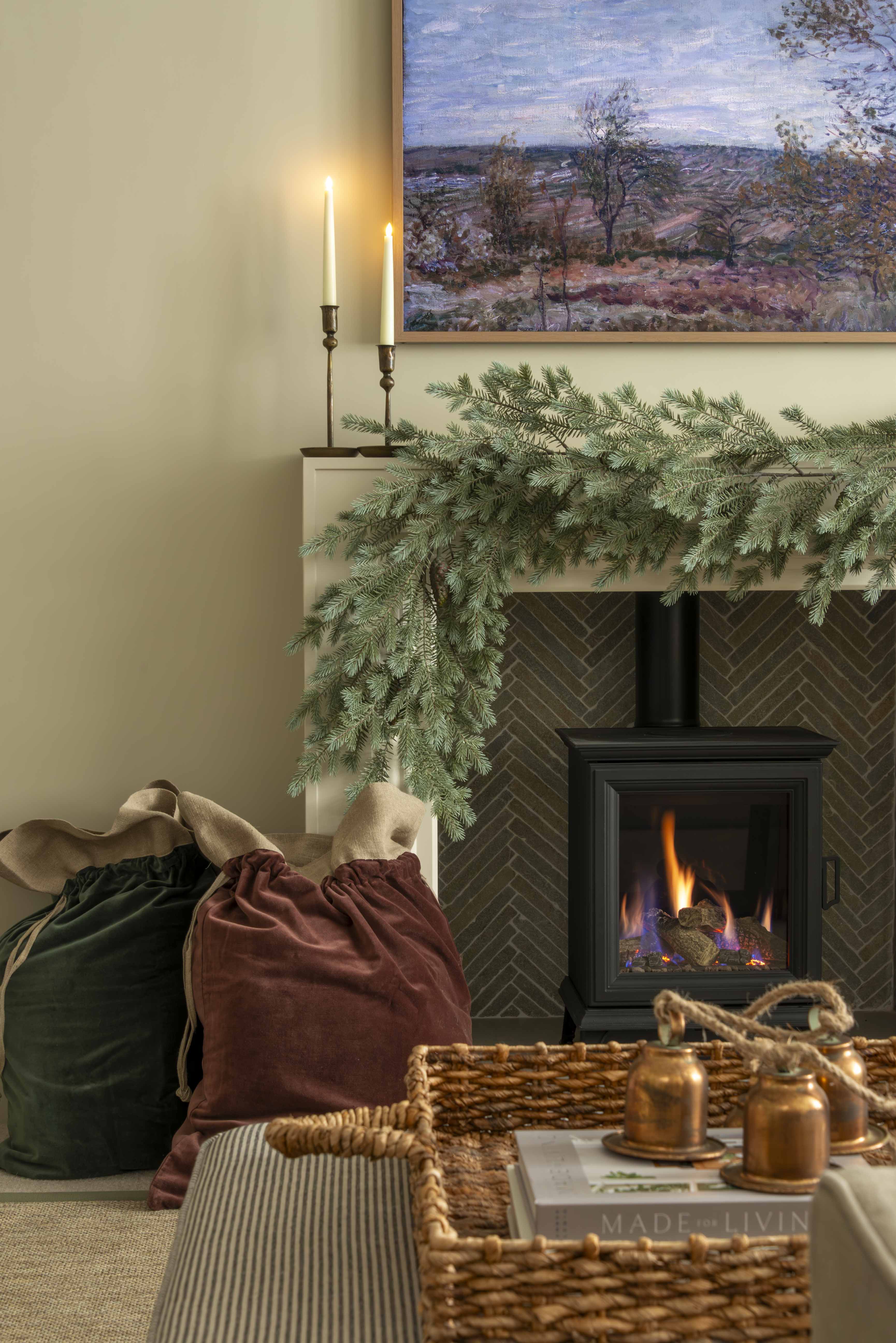 Charles Ted Noble Pine Garland with realistic pine branches and cones styled across a fireplace mantel