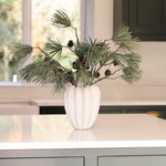 Charles Ted Scot's Pine Cone Spray with long pine needles and cones displayed in a white vase on a table