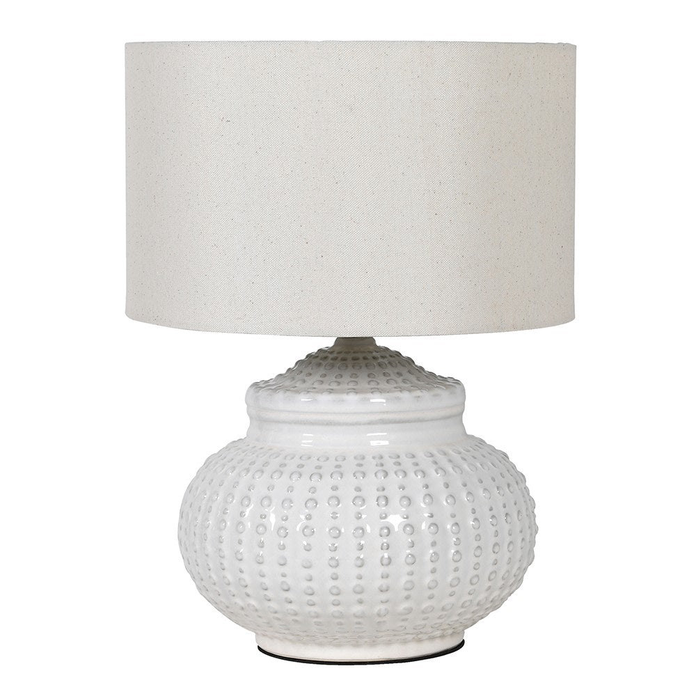This white ceramic lamp base features a unique pattern reminiscent of an urchin, accompanied by a coordinating linen shade.