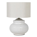 This white ceramic lamp base features a unique pattern reminiscent of an urchin, accompanied by a coordinating linen shade.