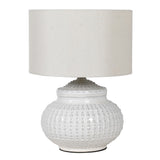 This white ceramic lamp base features a unique pattern reminiscent of an urchin, accompanied by a coordinating linen shade.