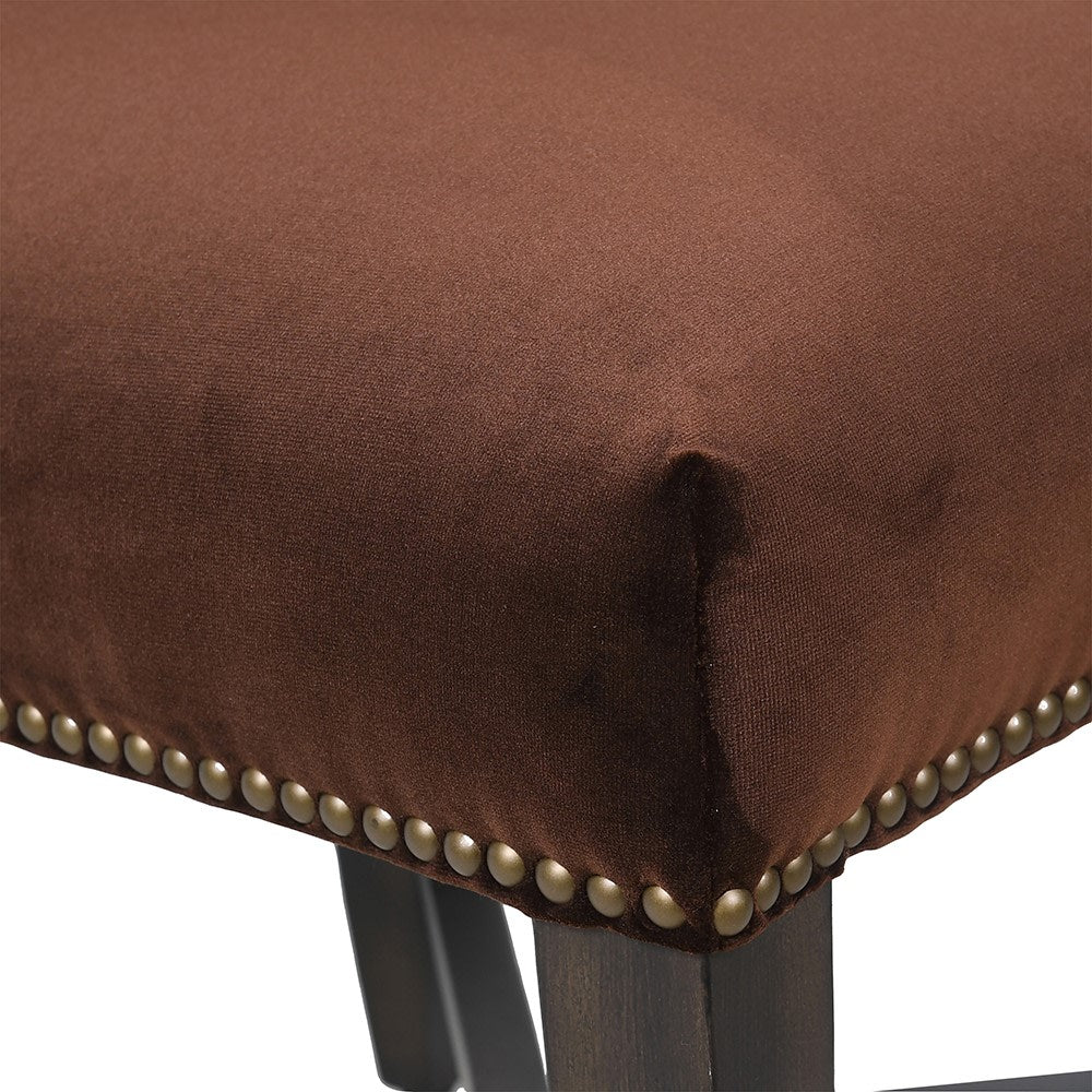 Close-up of nailhead trim detail on brown velvet dining chair