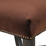 Close-up of nailhead trim detail on brown velvet dining chair