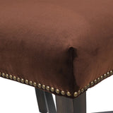 Close-up of nailhead trim detail on brown velvet dining chair