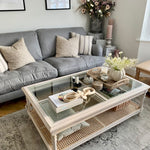 Rustic and elegant acacia wood coffee table with rattan and a glass top.