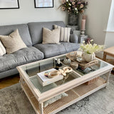 Rustic and elegant acacia wood coffee table with rattan and a glass top.