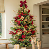 Decorated Christmas tree with red bows and ornaments in a living room.