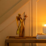 Decorative angel figure on a table with a candle next to a staircase