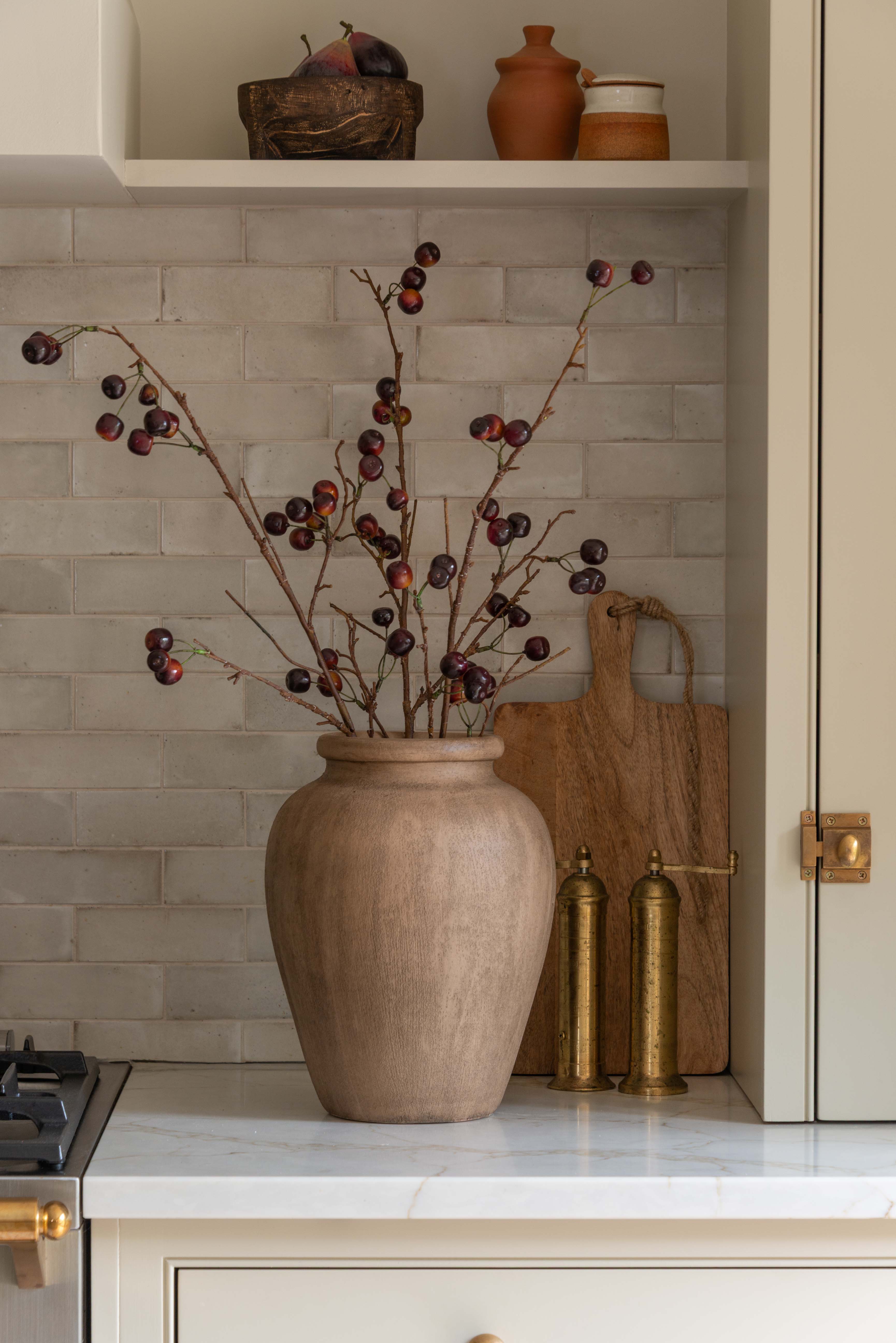 Charles Ted Faux Cherry Spray in a rustic vase styled against a tiled kitchen backsplash