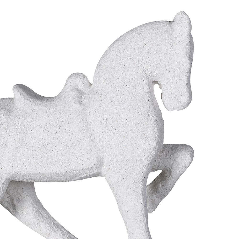 Close-up of textured white horse statue showing details of saddle and pose